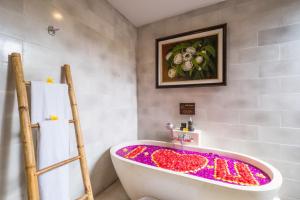 a bathroom with a bath tub covered in colorful glitter at Purana Boutique Resort in Ubud