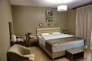 um quarto de hotel com uma cama e uma cadeira em Adana City Boutique Hotel em Adana