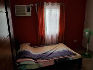 a small bed in a room with a window at Penthouse Apartment in Dagupan in Dagupan