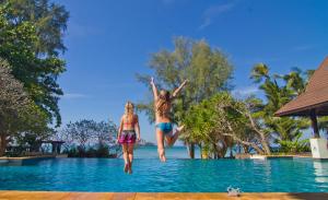 two girls jumping into a swimming pool at a resort at Barali Beach Resort & Spa in Ko Chang