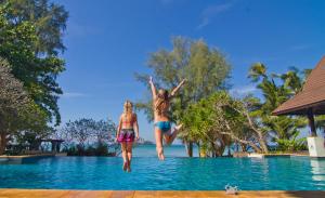 Zwei Mädchen springen in ein Schwimmbad in einem Resort in der Unterkunft Barali Beach Resort & Spa in Ko Chang