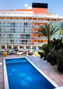 a swimming pool in front of a large building at Sol y Sombra in Benidorm