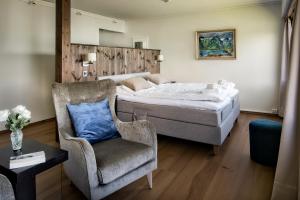 1 dormitorio con 1 cama y 1 silla en Dragsvik Fjordhotel en Balestrand