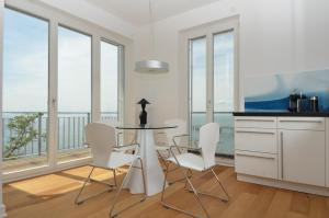 ザスニッツにあるOstseeresidenz Sassnitz F548 Penthouse 19 mit Sauna, Balkon, Meerblickのキッチン(テーブル、椅子付)、窓