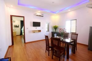 a dining room with a table and chairs and a television at DaNa Home Hotel - Apartment in Da Nang