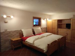 Un dormitorio con una cama grande y una ventana en Baita Rini, en Livigno