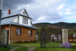 a wooden house with a gate in front of it at Faina House in Yaremche
