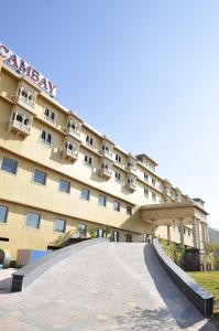 een groot gebouw met een oprit ervoor bij Cambay Resort, Udaipur in Udaipur