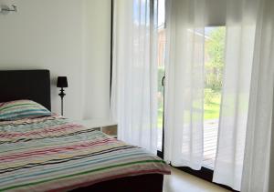 um quarto com uma cama ao lado de uma porta de vidro deslizante em Härmati Holiday House em Nasva