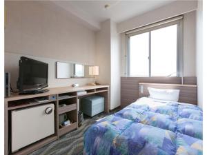 a hotel room with a bed and a television at Onomichi Daiichi Hotel in Onomichi