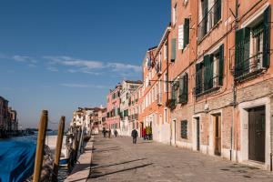 ヴェネツィアにあるCà Lessiaの通りを歩く人々と建物のある通り