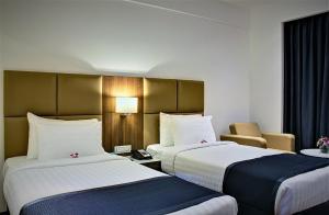 Postel nebo postele na pokoji v ubytování Ramada Encore Domlur Bangalore