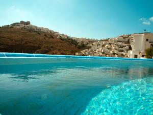 a pool of water with houses on a hill at Caldera Studios in Astypalaia