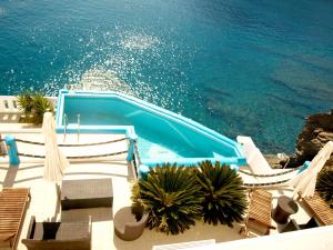 阿斯提帕莱亚镇克莱德拉公寓酒店的一个带椅子的露台和一个水边的游泳池