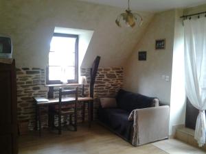 uma sala de estar com um sofá, uma mesa e uma janela em Le Martinou em Le Cayrol
