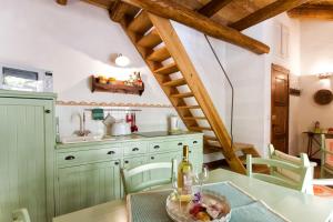 a kitchen with green cabinets and a table at Antiche Case in Pietra in Baunei +25 photos