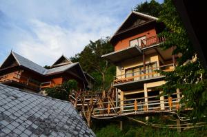 a house with a balcony and a roof at Phitharom PP Resort in Phi Phi Islands