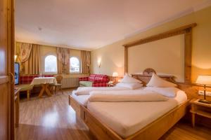 ein Schlafzimmer mit einem großen Bett und ein Wohnzimmer in der Unterkunft Das Rotspitz Adults - only in Maurach
