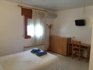 a bedroom with a bed and a table and a window at Posada Manolon in Santa Cruz de Moya