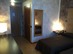 Schlafzimmer mit einem Bett, einem Spiegel und einer Tür in der Unterkunft Locanda Corte Girlanda in Verona