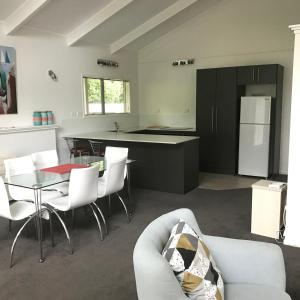 cocina y sala de estar con sofá y mesa en Ratanui Villas, en New Plymouth
