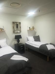 1 Schlafzimmer mit 2 Betten und einem Wandspiegel in der Unterkunft Den Skaldede Kok Guesthouse in Bindslev