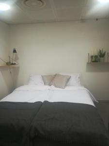 a bed with white sheets and pillows in a room at Den Skaldede Kok Guesthouse in Bindslev