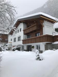 a building covered in snow in front of it at Haus Bergfrieden in Kaunertal