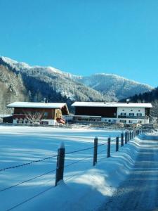 ウンターヴォッセンにあるBerghof Moarの雪の中に柵を持つ建物