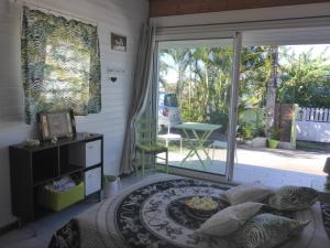 a living room with a bed and a large sliding glass door at La case o'gecko974 in Saint-Joseph