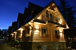 une maison avec des lumières sur son côté dans l'établissement Pokoje Gościnne BENITA, à Zakopane