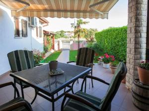 einen schwarzen Tisch und Stühle auf einer Terrasse in der Unterkunft Apartments Grozdanić in Fažana