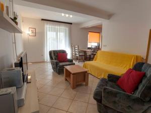 ein Wohnzimmer mit einem Bett, Stühlen und einem TV in der Unterkunft Apartments Grozdanić in Fažana