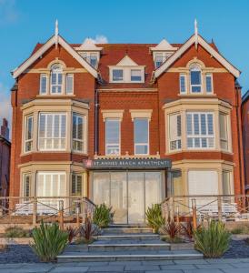 a large brick building with stairs in front of it at St Annes Beach Apartments in Lytham St Annes