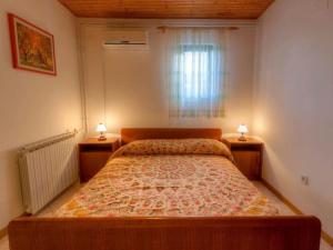 ein Schlafzimmer mit einem großen Bett mit zwei Nachttischen in der Unterkunft Apartments Grozdanić in Fažana