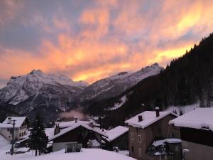 um pôr-do-sol sobre uma cidade com montanhas cobertas de neve em Civetta em San Tomaso