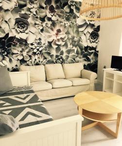 a living room with a couch and a floral wallpaper at Griffn Properties Lifestyle in Essen