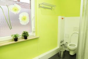 a bathroom with a toilet and a window with flowers on it at Charlotte Flat Heidelberg in Dossenheim +8 photos