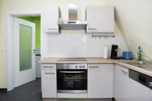 a kitchen with white cabinets and a stove at Charlotte Flat Heidelberg in Dossenheim