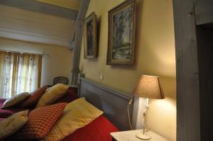 ein Schlafzimmer mit 2 Betten mit Kissen und einer Lampe in der Unterkunft Grange de la Herde in Camon