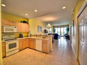 una cucina con armadietti in legno ed elettrodomestici bianchi di Harborview Grande 604 a Clearwater Beach