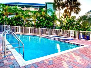 una piscina con una valla y palmeras en Harborview Grande 701, en Clearwater Beach