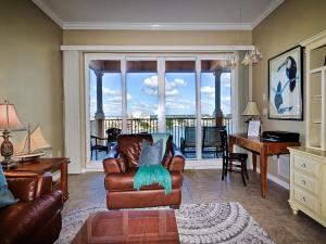 uma sala de estar com um sofá, uma secretária e uma janela em Harborview Grande 705 em Clearwater Beach