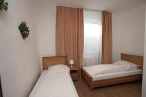 two beds in a small room with a window at Pension Club Montana in Câmpina