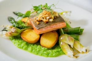 a white plate of food with carrots and peas at Serendipity Country House & Restaurant in Wilderness
