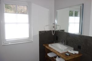 La salle de bains est pourvue d'un lavabo et d'un miroir. dans l'établissement Haus Dumicketal, à Drolshagen