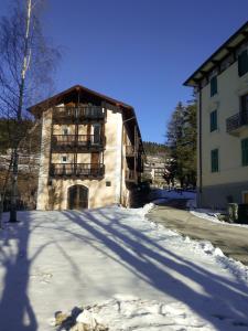 um edifício com uma varanda na neve em Villa Paola em Lavarone