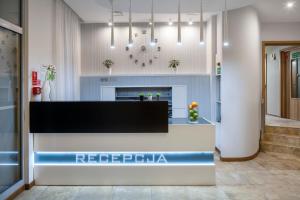 a reception desk in a lobby with a clock at Hotel Aqua Sopot - Destigo Hotels in Sopot
