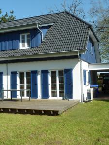una casa con persianas azules y porche en Haus Sturmschwalbe, en Ummanz