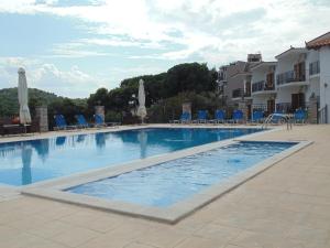a large swimming pool with chairs and umbrellas at Skiathos Diamond in Kolios